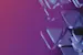 Abstract 3D glass geometric shapes floating against a purple and blue gradient background with reflective surfaces.