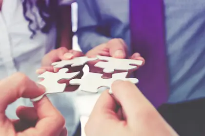people holding jigsaw puzzle pieces