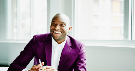 smiling-businessman-in-discussion-at-workstation