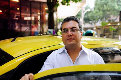 Driver of a taxi stands near his car