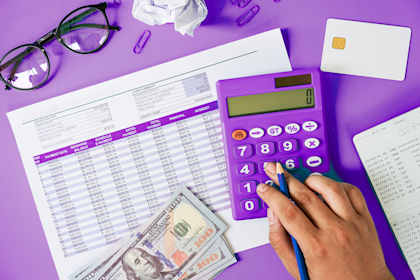 Hand calculating bills on desk