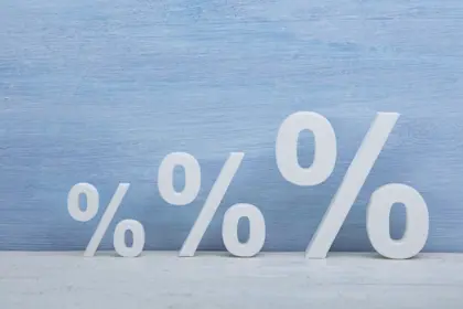 Three percentage signs increasing in size in front of a sky blue background 