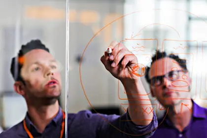 Businessman drawing diagram on glass wall