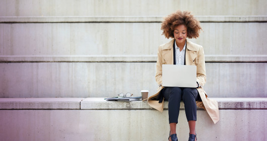 Woman sitting on bench with laptop