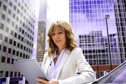 Business woman using tablet outside building