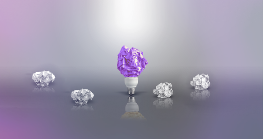 Conceptual photo of crumbled paper and light bulb
