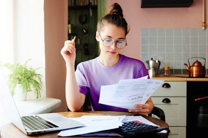 Indoor picture of young European female sitting a a table at home.
