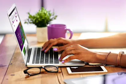 shot of a woman's hands typing on a laptop computer