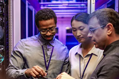 Three IT engineers using a digital tablet
