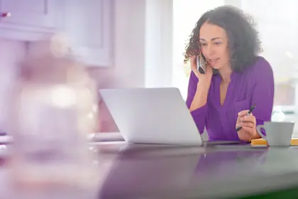 woman working on laptop and talking on phone