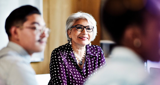 Smiling mature female business owner listening during presentation