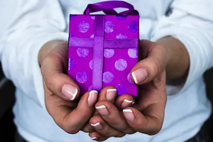 Girl holding a purple gift in her hand