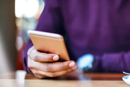 Person's hand holding mobile phone