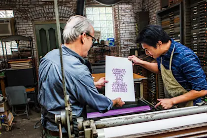 Workers examining letterpress paper in workshop