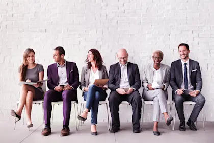 SIx business people sitting in row of chairs