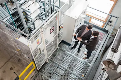 Two businessmen looking at tablet in factory setting