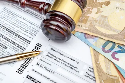Money, a gavel and pen on the German tax form