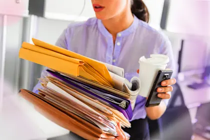 Business woman holding stack of documents in office