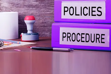 Large purple binders labeled "Policies" and "Procedures"