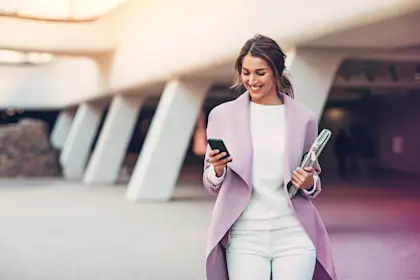 Woman walking while checking cell phone