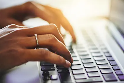 Closeup shot of a woman typing on a laptop