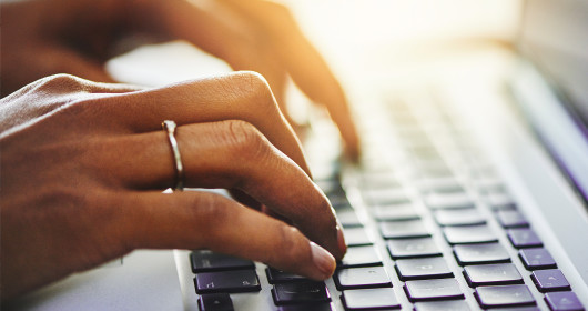 Closeup shot of a woman typing on a laptop