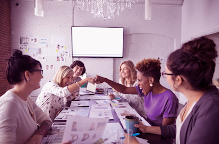 Team of women around table looking over reports