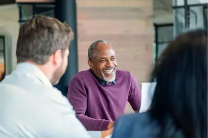 Man in purple sweater at meeting