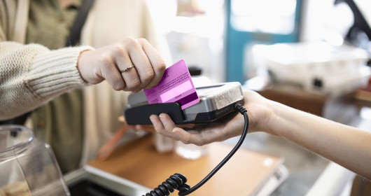 Woman swiping credit card at a store checkout