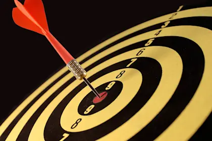 Dart sitting in bulls-eye of dart board