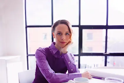 Confident female architect with blueprints in conference room