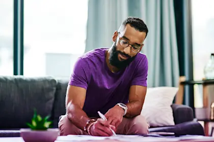 man signing documents at coffee table