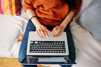 Overhead close up of a young woman working on laptop