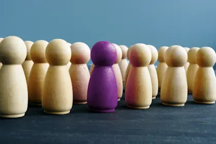 one purple wooden figures among others on a desk