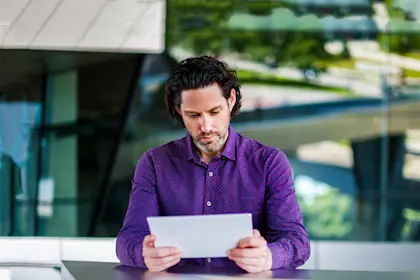 man sitting at table with an outdoor veiw