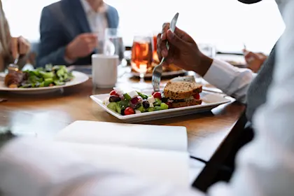 businessman eating a sandwich and salad witch colleagues