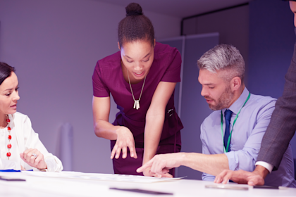 Businesswoman talking to colleagues in a meeting.