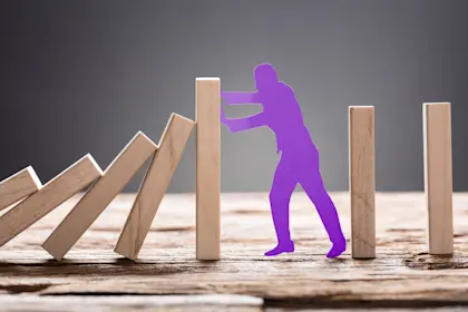 Purple Paper Man Stopping Wooden Domino Blocks