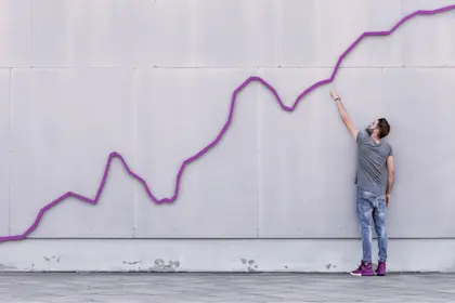 Man pointing to purple line graph on a wall