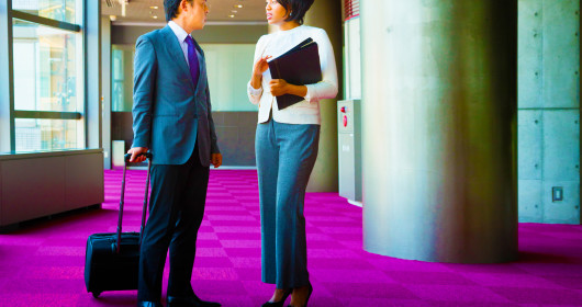 businessman and businesswoman chatting in hallway