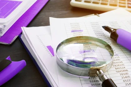 Magnifying glass sitting on top of paper charts