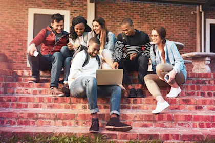 Group sitting on steps looking at computer
