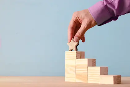 Blocks stacked up like stairs with star on top stair