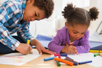 children coloring on living room floor