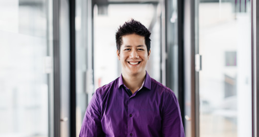 portrait of an office employee standing in a corridor, smiling