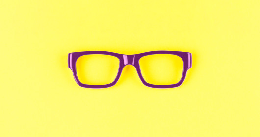 purple eye glasses on yellow background