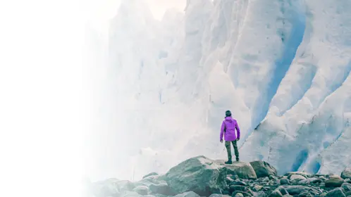 Person standing at the base of a mountain