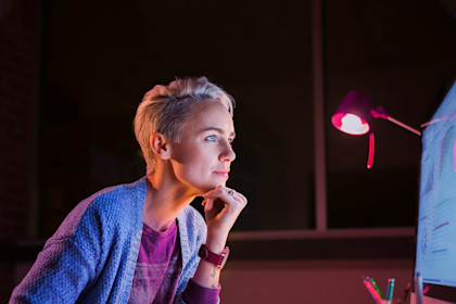 Woman working late at computer in office