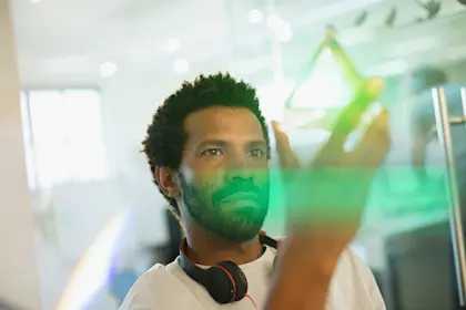 Male entrepreneur examining glass prism