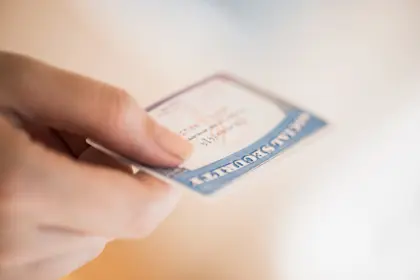 Close up photo of a woman's hand holding a social security card